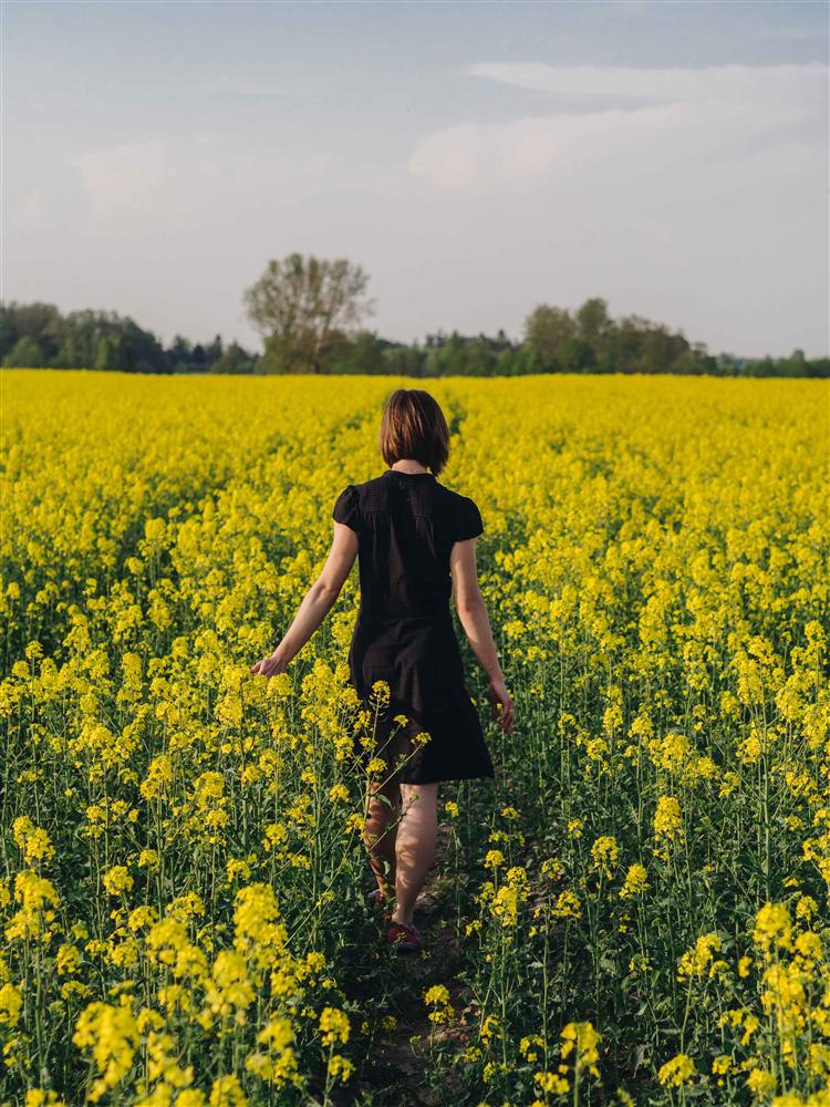 woman in little black dress in a field of flowers
